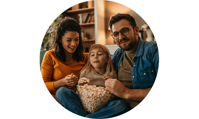 Man, woman and girl eating popcorn