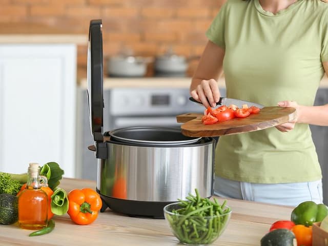 Dame legger ingredienser oppi kokeren