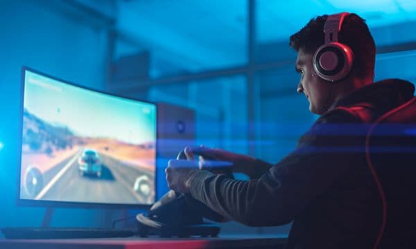 A gamer playing rally video game with steering wheel