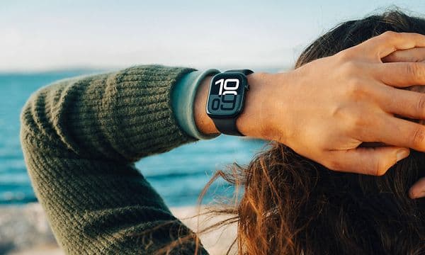Kvinne på stranden med en Apple Watch på håndleddet.