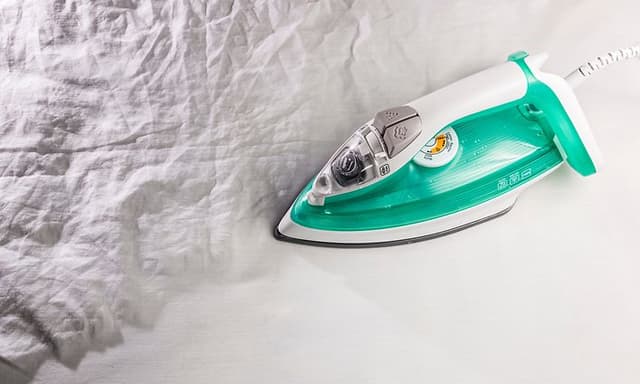 A large piece of white garment being ironed