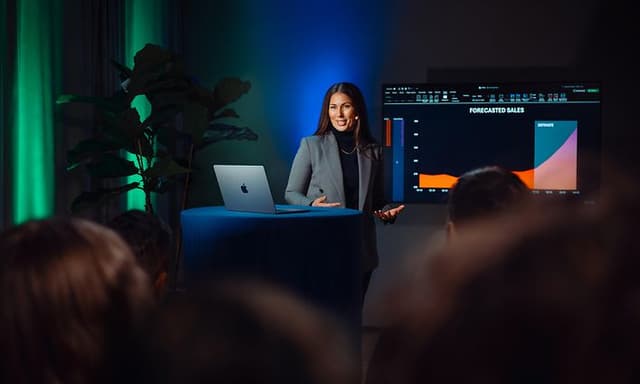 Nainen esitelmöi MacBook Air pöydällä hänen vieressään