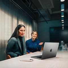 Elgiganten företagsrådgivare hjälper en kund med sin MacBook