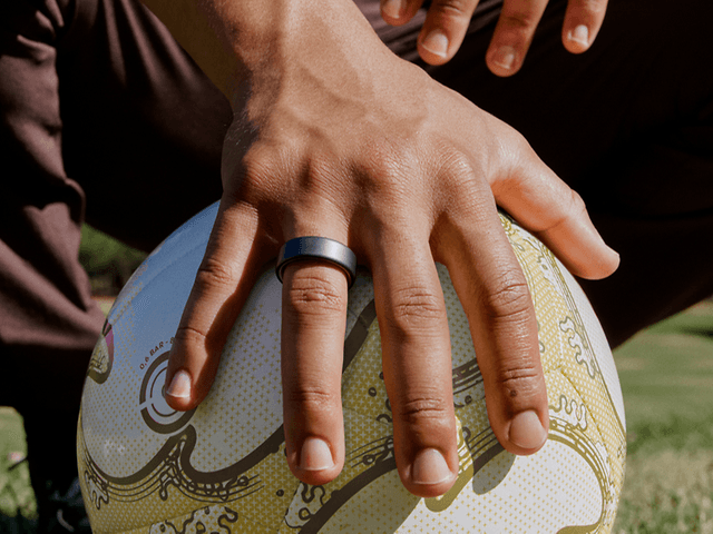 hand with smart ring on football