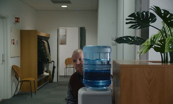 Mand gemmer sig bag en vandkøler