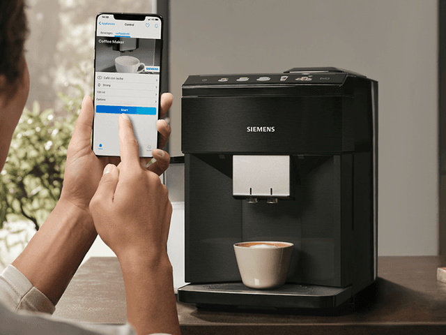 Person bruker Home Connect-appen for å styre Siemens EQ500 kaffemaskin