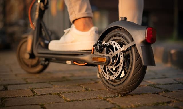 Nærbilde av testvinnere Ninebot Segway Electric Scooter med en mann som bruker den