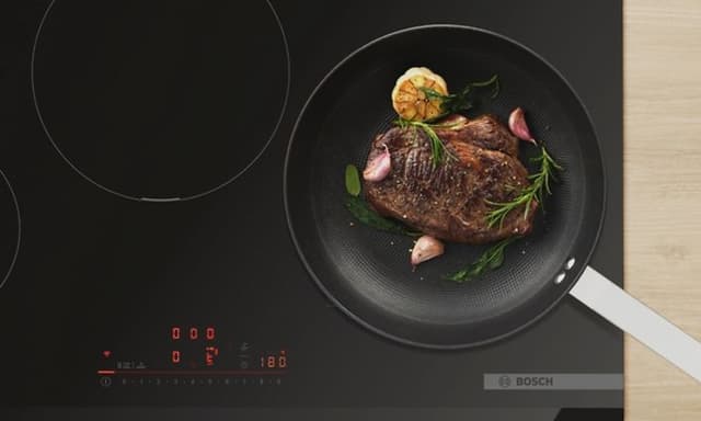 Kjøtt stekes i en stekepanne på Bosch induksjonstopp