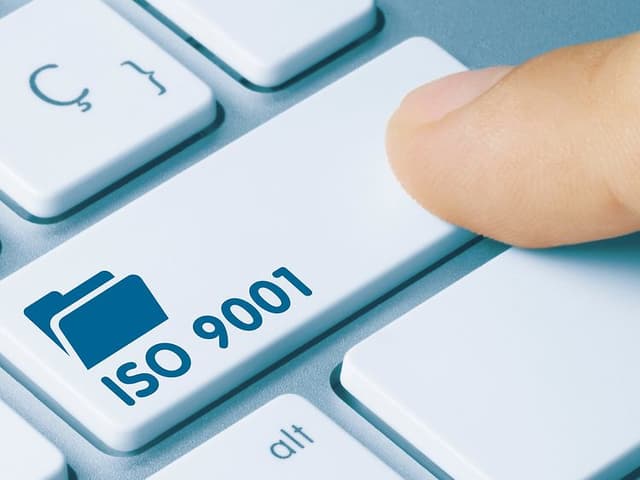 Finger trykker tast med ISO 9001