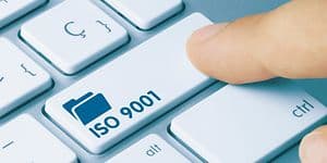 Finger trykker tast med ISO 9001