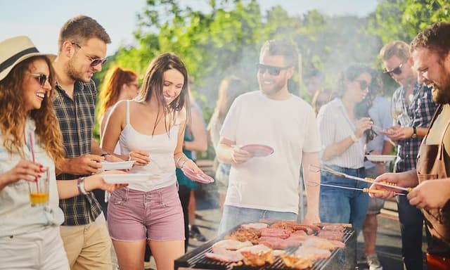 Bedste grill: Folk omkring en grill, hvorfra de serverer sig selv og hygger sig