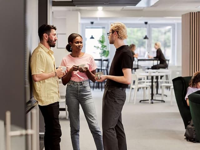 Three employees talking to each other in the office