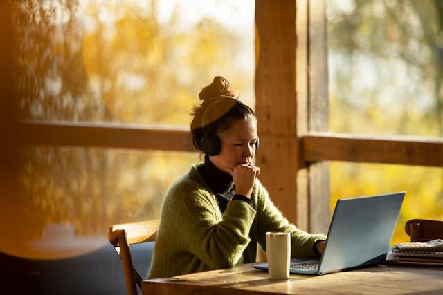 Thoughtful looking woman working on her laptop