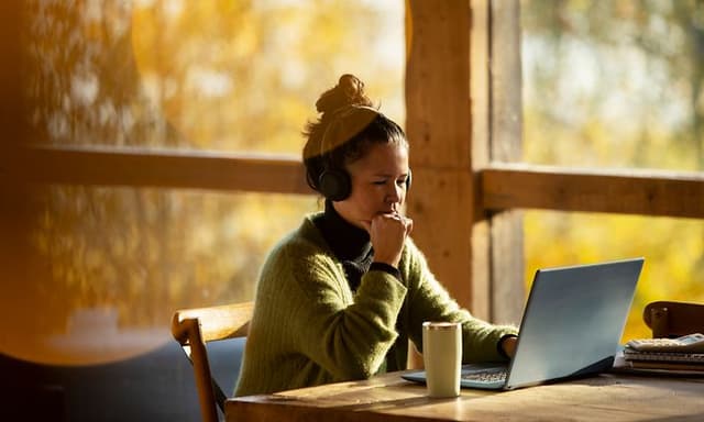 Thoughtful looking woman working on her laptop
