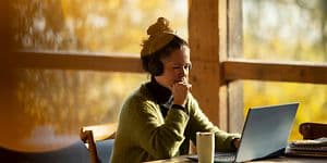 Thoughtful looking woman working on her laptop