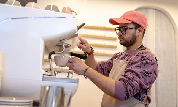 Mies käyttää ammattitason espressokeitintä