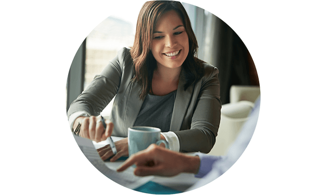 Smilende kvinne som snakker med en kollega i et møte