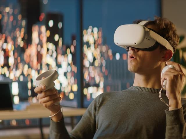VR-briller på hovedet af mand, der gamer med indlevelse