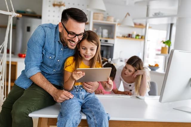 Man and girl looking at tablet