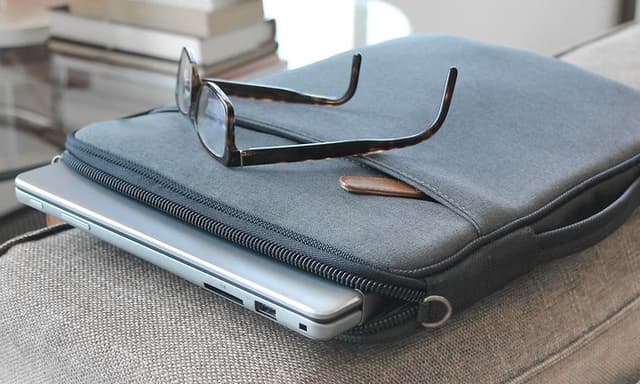 Datorer - Tillbehör - Laptop i ett grått laptopfodral på ett bord