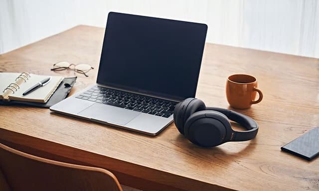 Arbejdscomputer og Sony høretelefoner på skrivebord