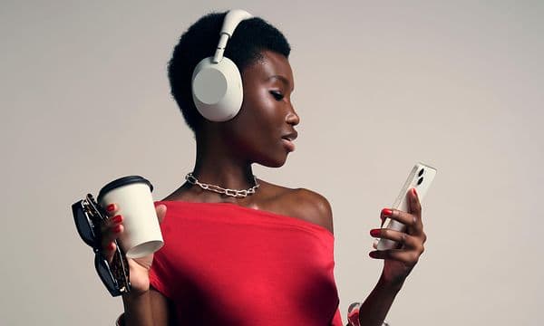 Sony WH-1000x m6 -Woman with headphones looking at phone