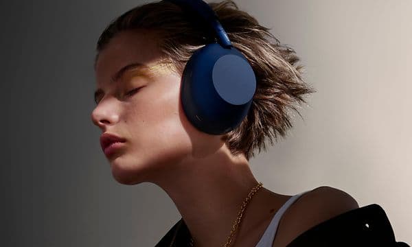 Sony WH-1000x m6 -kuulokkeet päässä oleva nainen, jolla on silmät kiinni