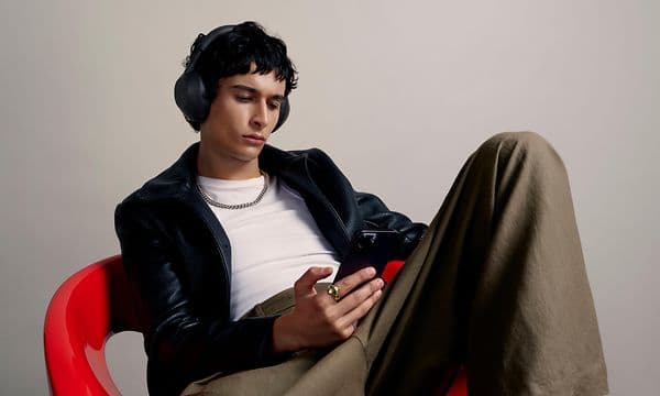 Sony-WH-1000x-m6---man-with-headphones-looking-at-phone