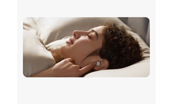 Woman in bed with Soundcore sleep