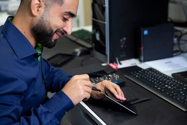 Telefonreparation foretages af en mand fra Elgiganten