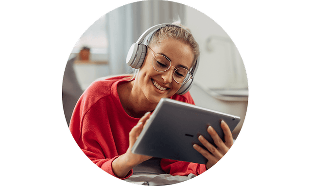 Kvinde med tablet i hånden og høretelefoner på