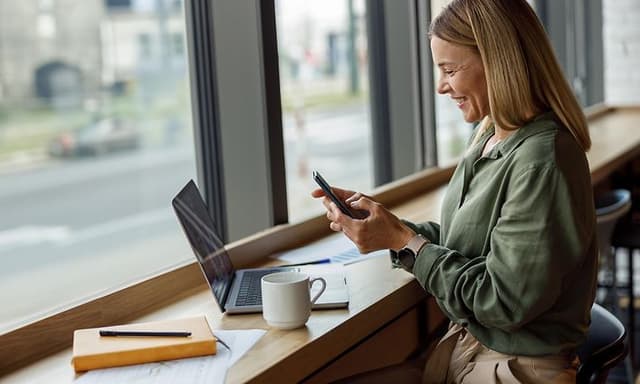 Laptop på bord på café med en kvinde