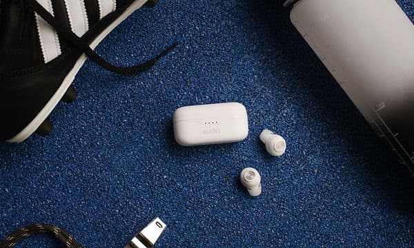 White Sudio T3 next to football shoes