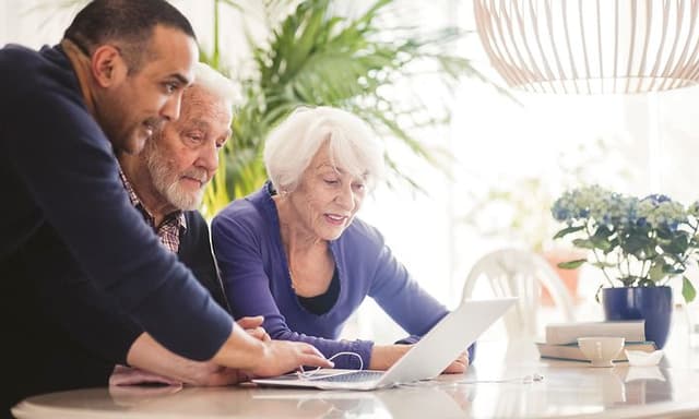 Computing - AI PC - Man helping an old man and woman to use a laptop