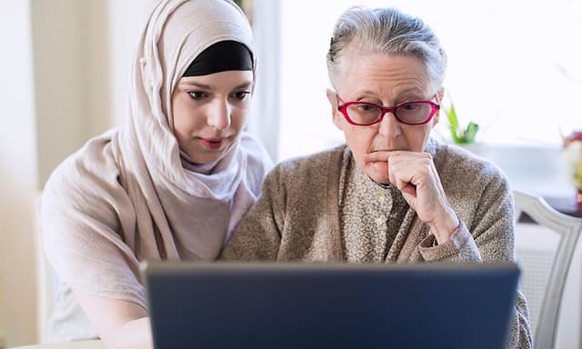 Computing - AI PC - Younger woman helping an older woman using laptop