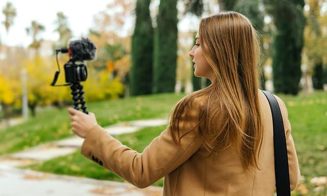 Kvinde går en tur i parken, mens hun vlogger