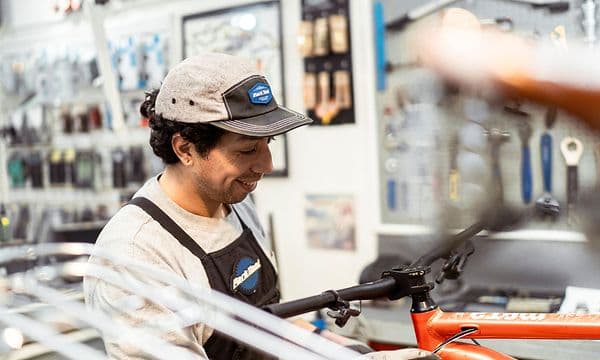 Smilende mand arbejder på at reparere en cykel