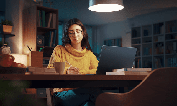 Computing - ASUS - En kvinde der bruger en Chromebook på et spisebord