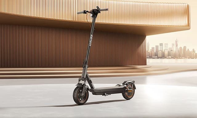 Navee - GT3 -sähköpotkulauta parkkeerattuna modernin rakennuksen eteen