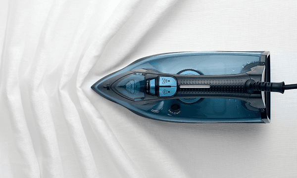 Apt Steam Iron ironing a white sheet ensuring zero wrinkles