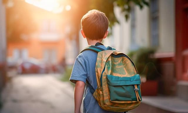 Nuori poika kävelee ulkona reppu selässään
