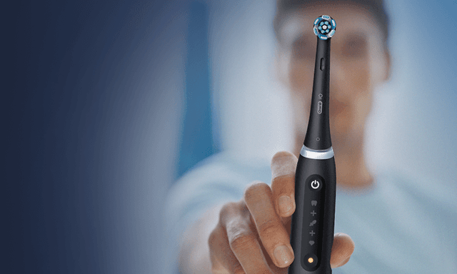 Guy holding toothbrush