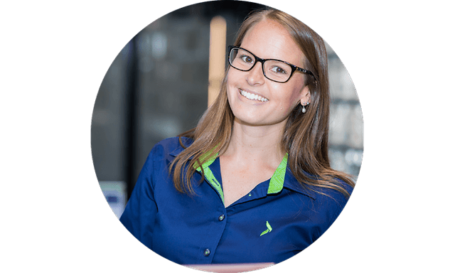 Smilende kvindelig Elgiganten-medarbejder iført sin arbejdsuniform