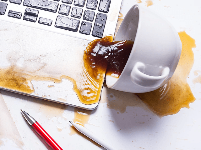 kaffekopp veltet og sølt utover en laptop