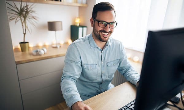 Mies työskentelee etänä kotonaan