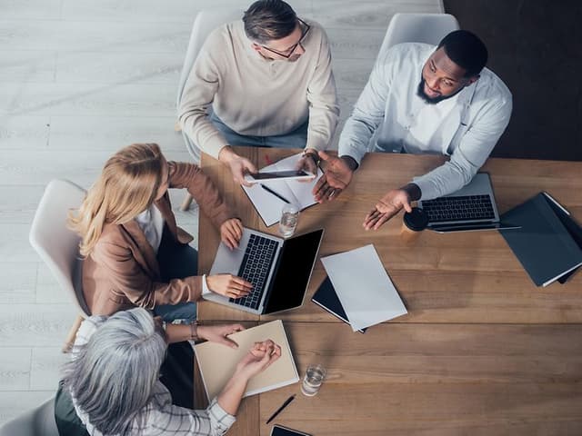 Mennesker med datamaskiner på møterom