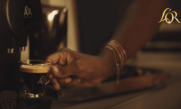 Person laver en kop kaffe med en L'Or Barista kapselmaskine