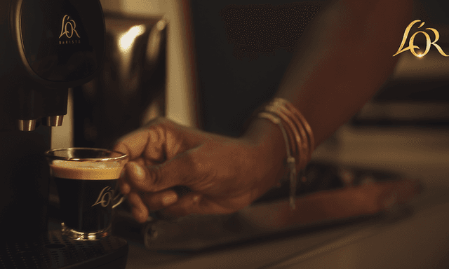 Person making a cup of coffee with the L'Or Barista capsule machine