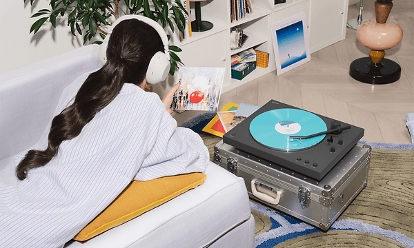 Person der lytter til vinylplader på en Sony LX3BT-pladespiller med Bluetooth-høretelefoner