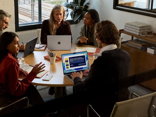 Apple - B2B - People around a table working with Apple products
